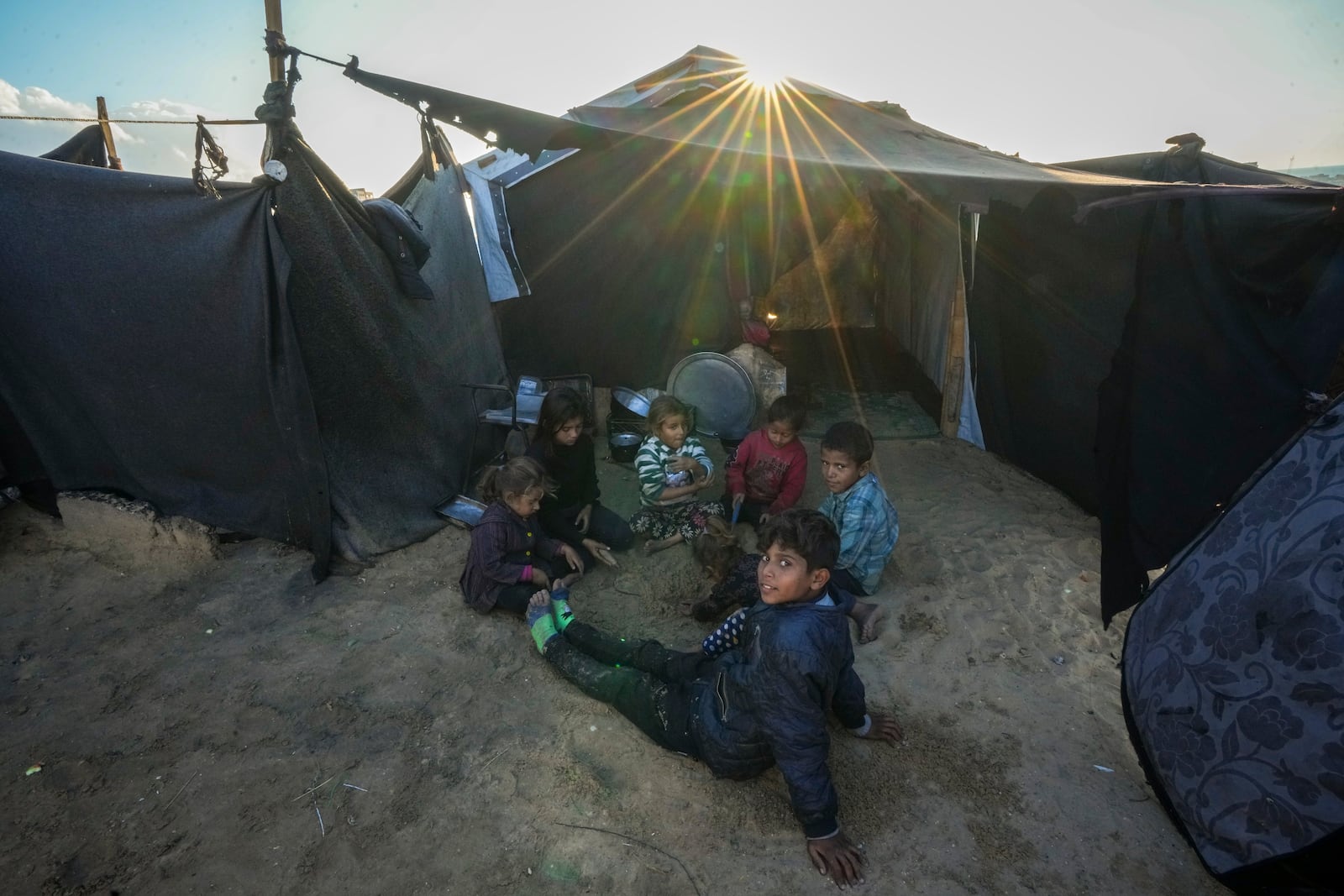 Grandchildren of Reda Abu Zarada, displaced from Jabaliya in northern Gaza, play next to their tent at a camp in Khan Younis, Gaza Strip, Thursday, Dec. 19, 2024. (AP Photo/Abdel Kareem Hana)