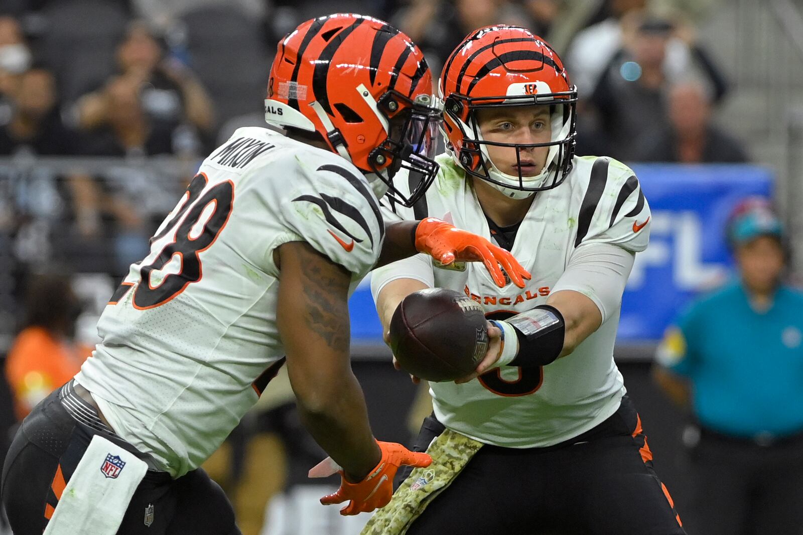 Cincinnati Bengals quarterback Joe Burrow (9) hands off the ball to running back Joe Mixon (28) during the first half of an NFL football game against the Las Vegas Raiders, Sunday, Nov. 21, 2021, in Las Vegas. (AP Photo/David Becker)