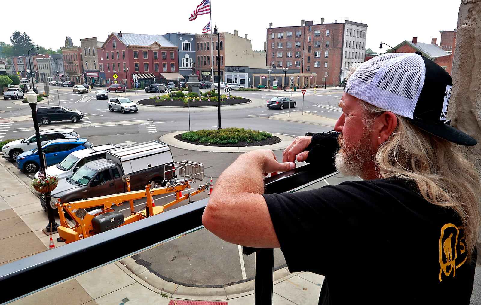 Before opening Thursday, June 29, 2023, Matt Miller, a bartender at the Urbana Brewing Co., looks out over downtown Urbana from the Brewing Co.'s roof top terrace. BILL LACKEY/STAFF