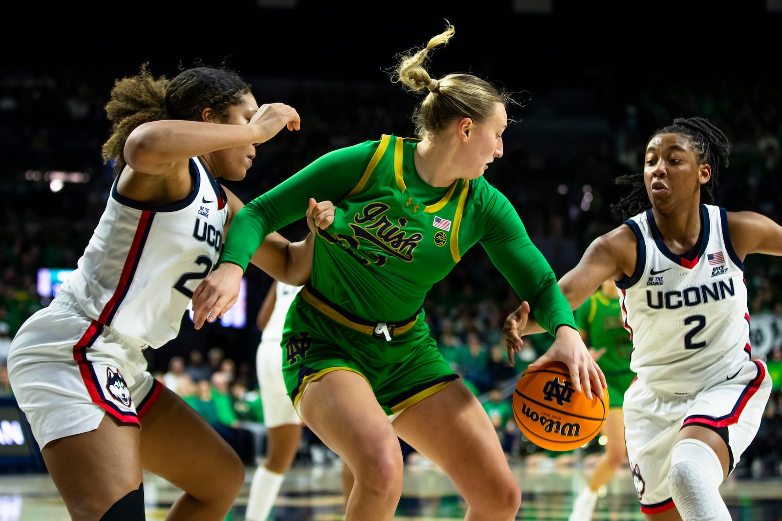 Notre Dame forward Liza Karlen, center, fights for possession with UConn forward Ice Brady, left, and guard KK Arnold (2) during the second half of an NCAA college basketball game Thursday, Dec. 12, 2024, in South Bend, Ind. (AP Photo/Michael Caterina)