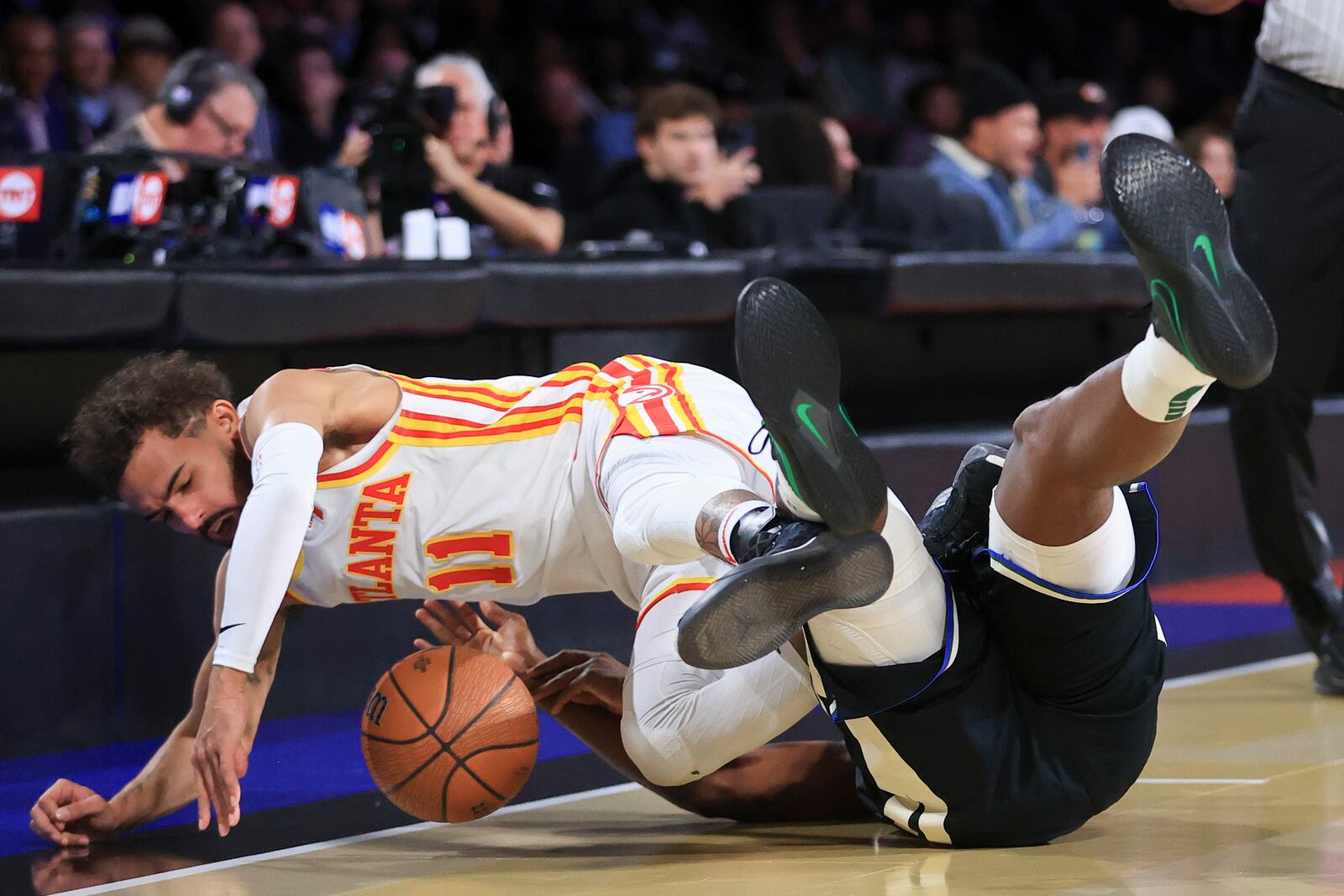 Atlanta Hawks guard Trae Young (11) collides into Milwaukee Bucks forward Khris Middleton, right, during the first half of a semifinal game in the NBA Cup basketball tournament Saturday, Dec. 14, 2024, in Las Vegas. (AP Photo/Ian Maule)