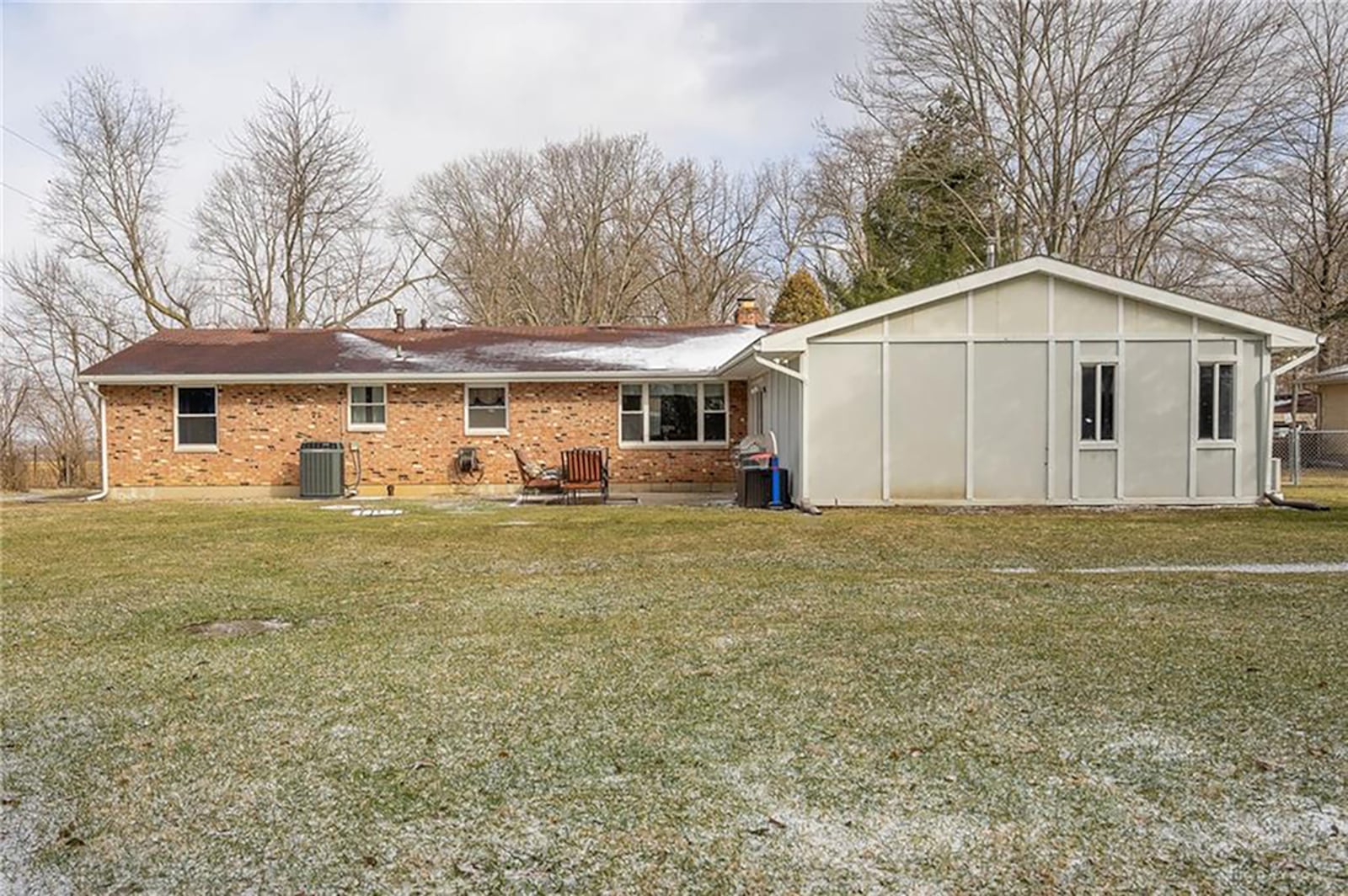 The rear of the home is fenced and has a concrete block patio, a mature tree line, brick firepit and yard barn. CONTRIBUTED PHOTO