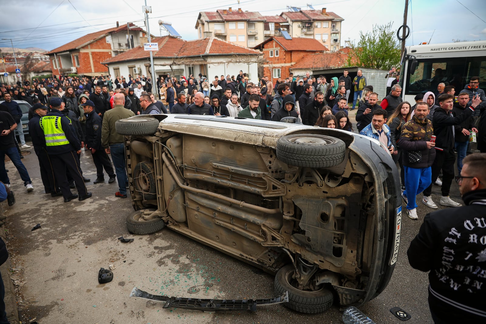 A vehicle is overturned by people protesting near the home of the owner of a nightclub that was the scene of a massive fire, after a vigil for the victims in the town of Kocani, North Macedonia, Monday, March 17, 2025. (AP Photo/Armin Durgut)