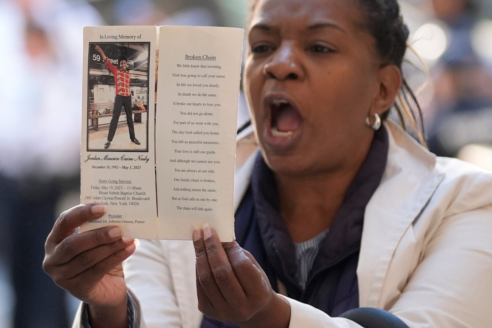 A woman yells and holds up a picture of Jordan Neely just before Daniel Penny arrives to Manhattan criminal court in New York, Monday, Oct. 21, 2024. (AP Photo/Seth Wenig)