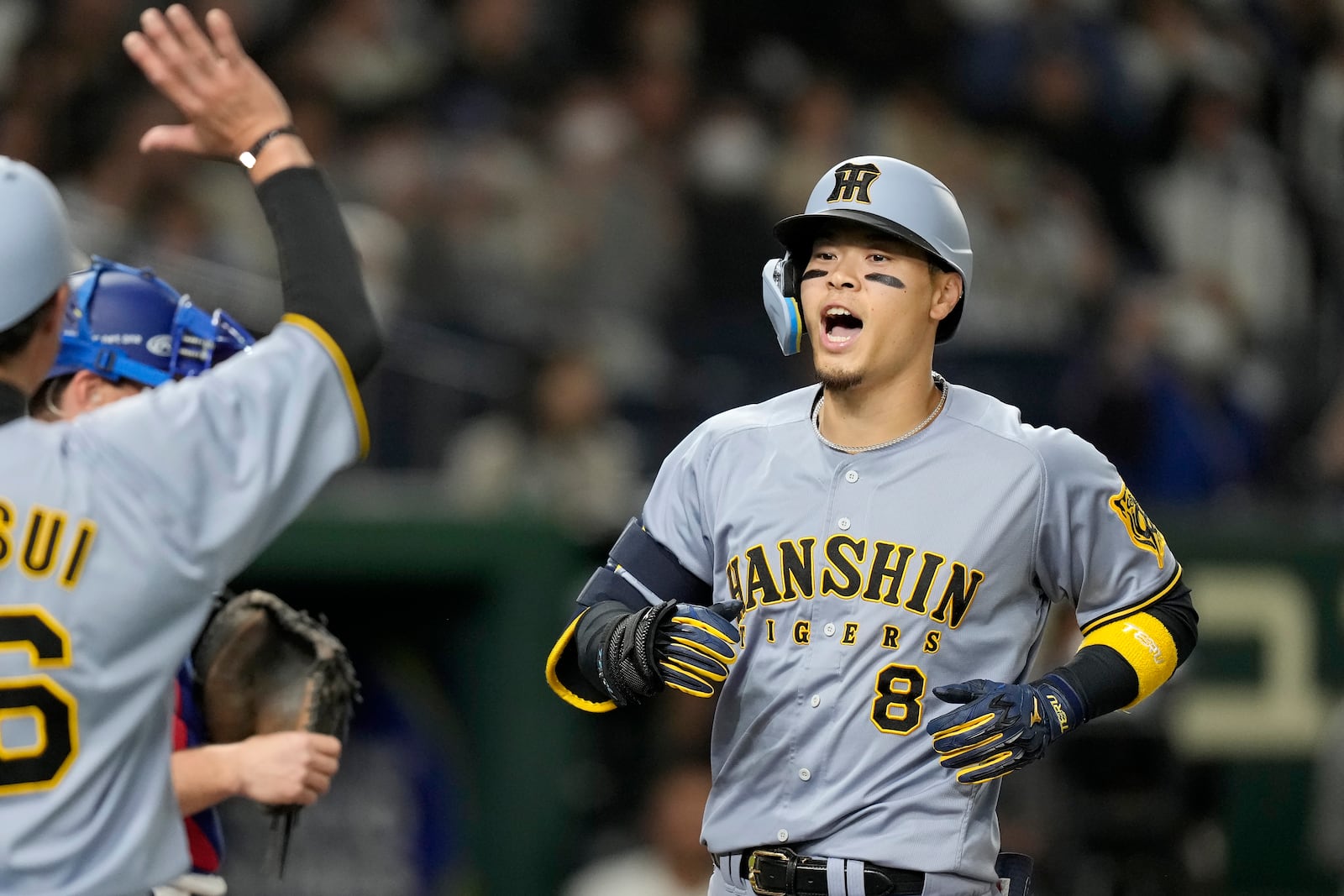 Hanshin Tigers' Teruaki Sato (8) celebrates after hitting a three-run home run against the Los Angeles Dodgers during the fourth inning in an MLB Japan Series exhibition baseball game, Sunday, March 16, 2025, in Tokyo. (AP Photo/Hiro Komae)