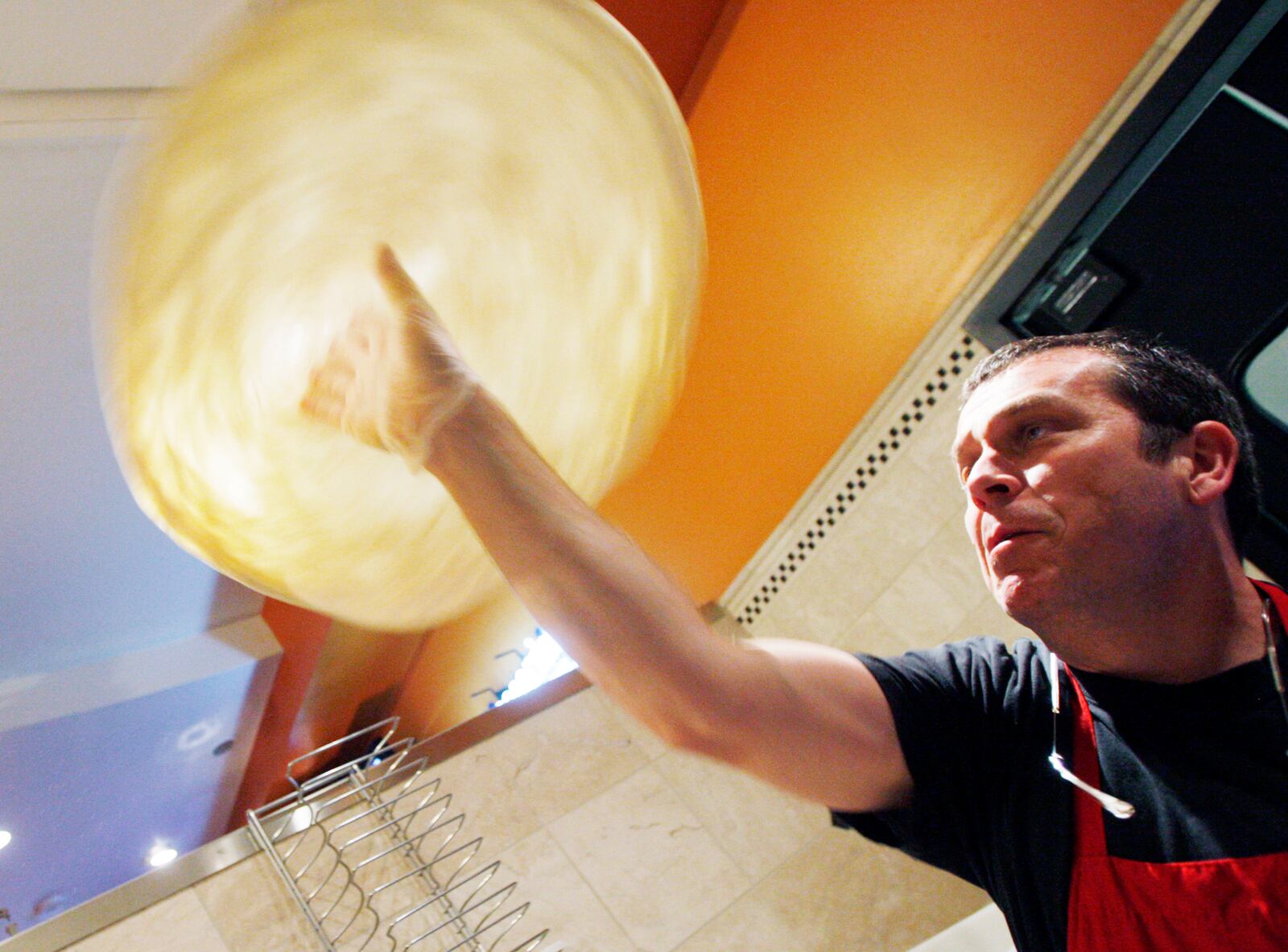 In this file photo from 2011, Glen Brailey, founder and owner  of Spinoza's Pizza & Salads prepares pizza dough at the restaurant inside the Mall at Fairfield Commons.