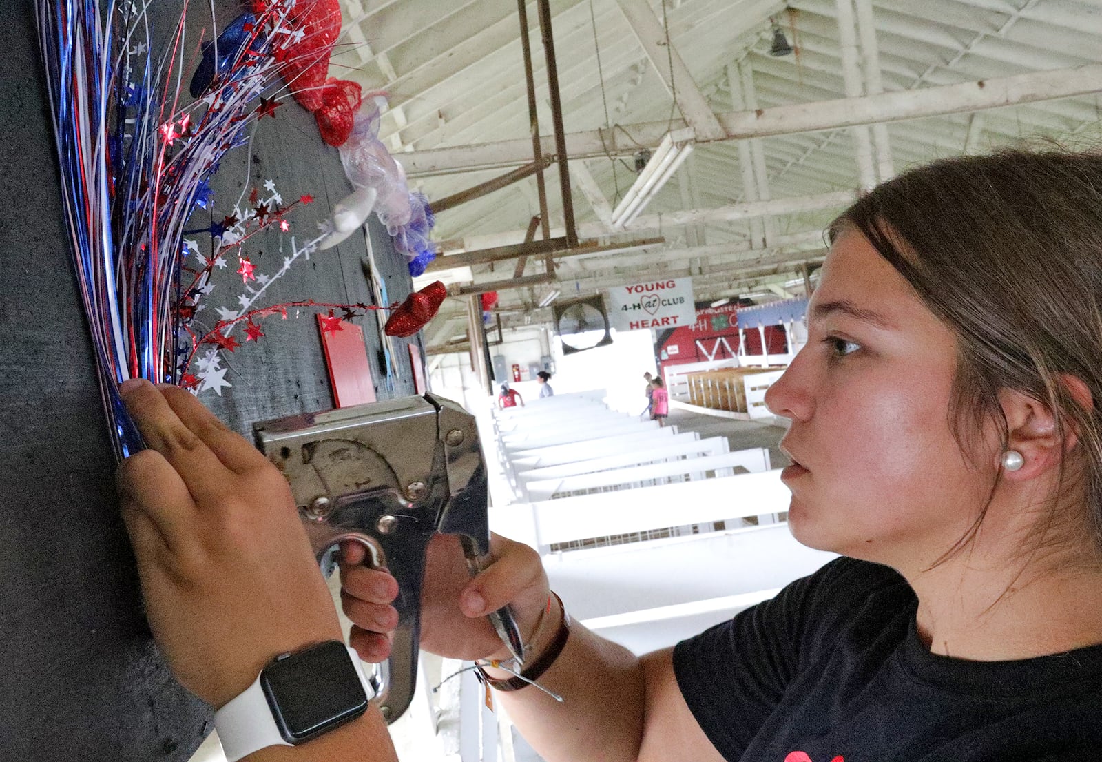 Makenna Young decorates the Young at Heart 4-H Club's area in one of the barns Wednesday in preparation for the Clark County Fair's start on Friday. BILL LACKEY/STAFF