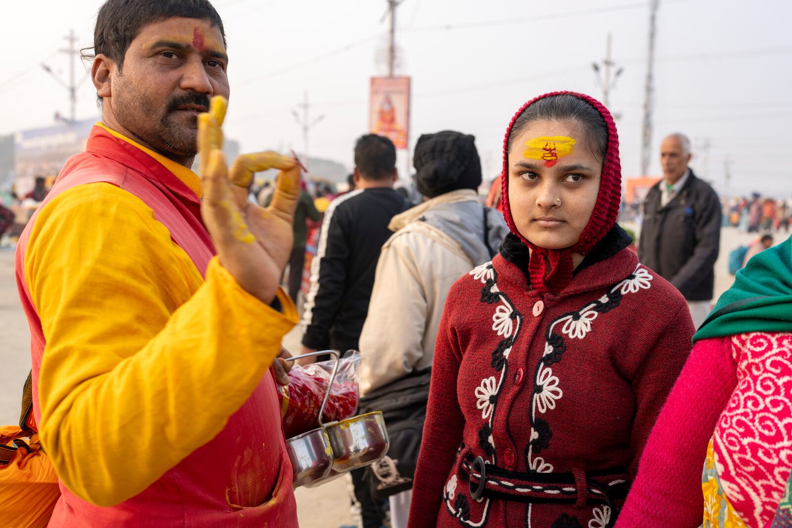 A Hindu priest, left, gestures after putting sacred marks on the forehead of a devotee at the confluence of the Ganges, the Yamuna, and the Saraswati rivers during the 45-day-long Maha Kumbh festival in Prayagraj, India, Tuesday, Jan. 14, 2025. (AP Photo/Ashwini Bhatia)