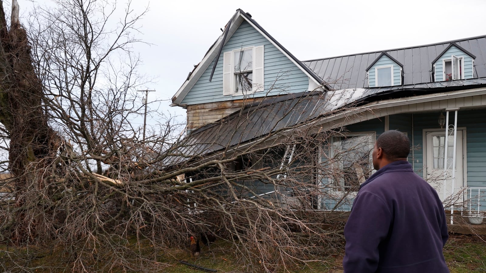 Jerome Thomas looks over the damage to his house in northwest Clark County after a tree fell on it during the Monday afternoon, Feb. 28, 2023, storm. The National Weather Service in Wilmington confirmed a tornado touched down in Clark County as a severe thunderstorm passed through the region. BILL LACKEY/STAFF