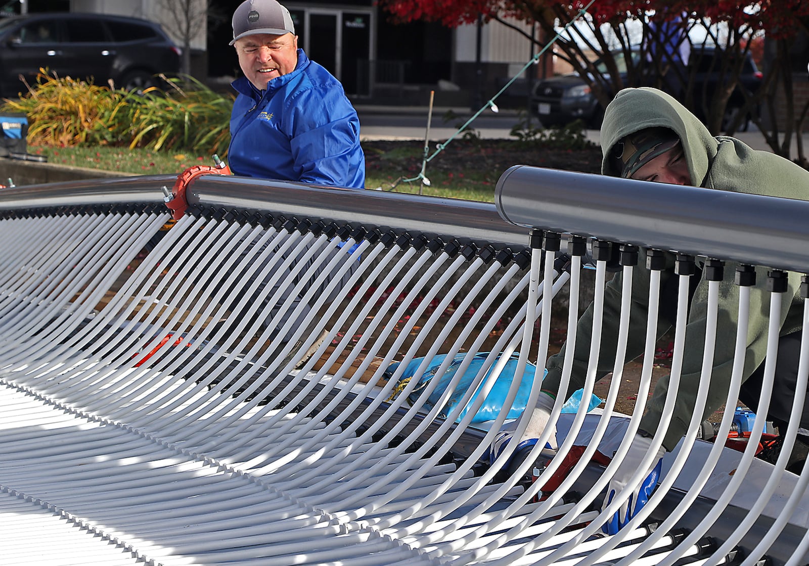 A crew from All Year Sports Galaxy works to build a temporary ice skating rink on the Springfield City Hall Plaza Thursday. The workers unrolled sheets of plastic tubing that will cool the water from underneath. The Greater Springfield Partnership will open the skating rink on Nov. 26 at 5 p.m. prior to the city’s Grand Illumination event. The ice rink, which is 40 feet by 80 feet, will be open on Thursdays through Sundays until Jan. 2. The cost to use the ice rink will be $5, including skate rental.. BILL LACKEY/STAFF