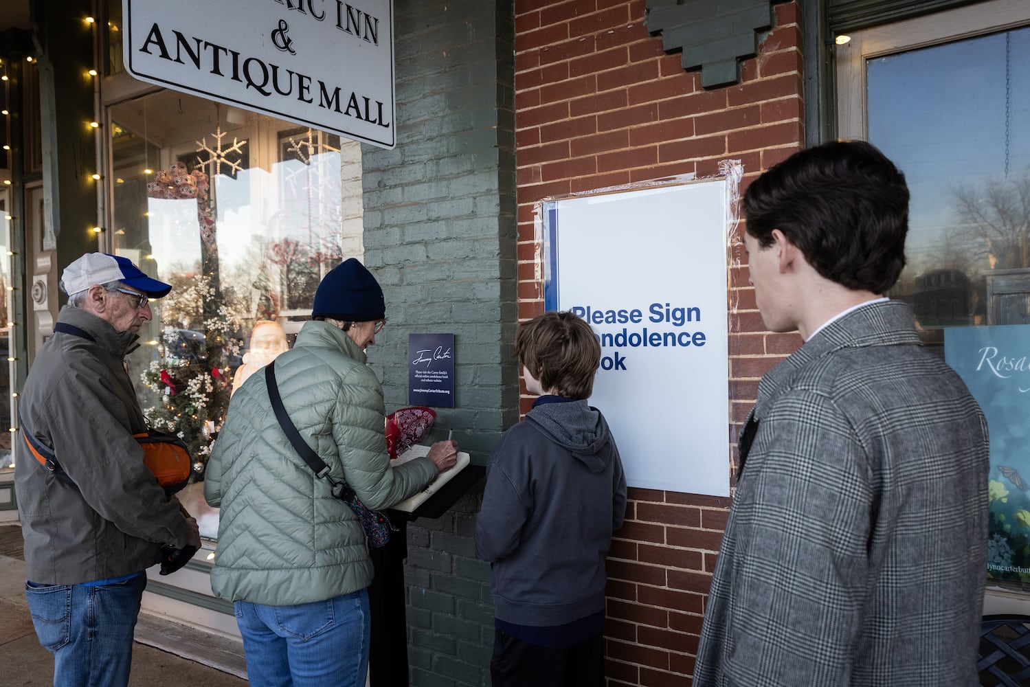 People sign a condolence book near the main street of Plains, Ga., on Jan. 4, 225, before a funeral procession for President Jimmy Carter. (Dustin Chambers/The New York Times)