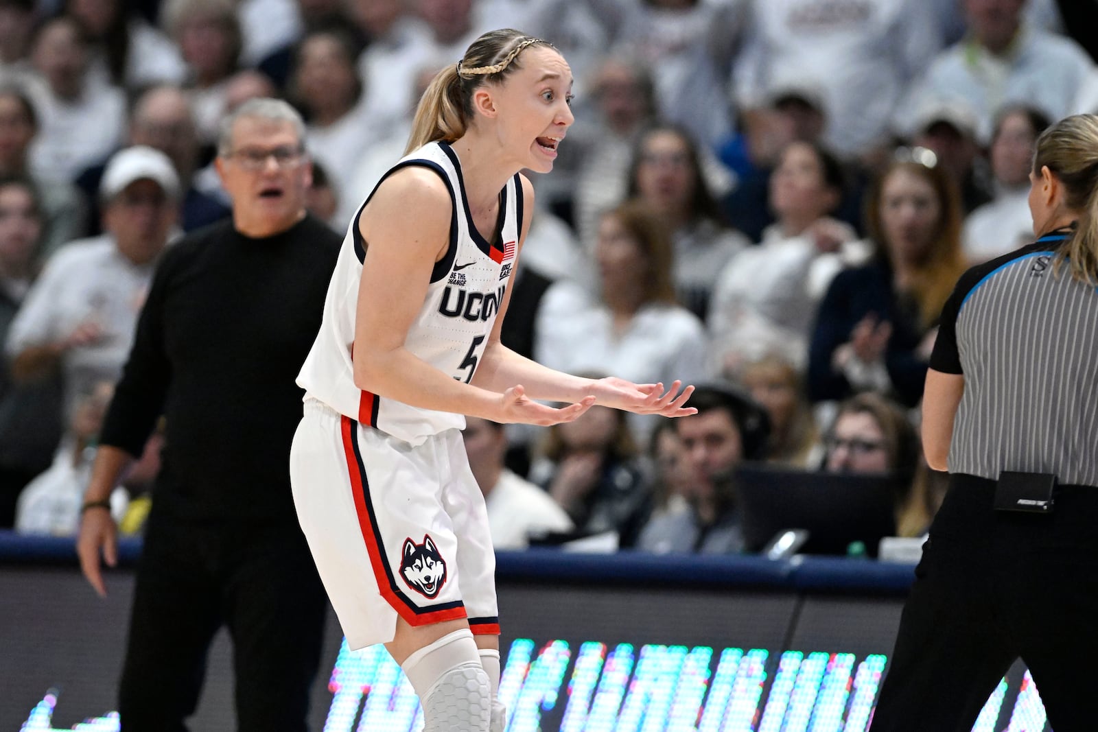 UConn guard Paige Bueckers, front left, reacts toward an official, right, after being called for a moving screen in the second half of an NCAA college basketball game against Southern California, Saturday, Dec. 21, 2024, in Hartford, Conn. (AP Photo/Jessica Hill)