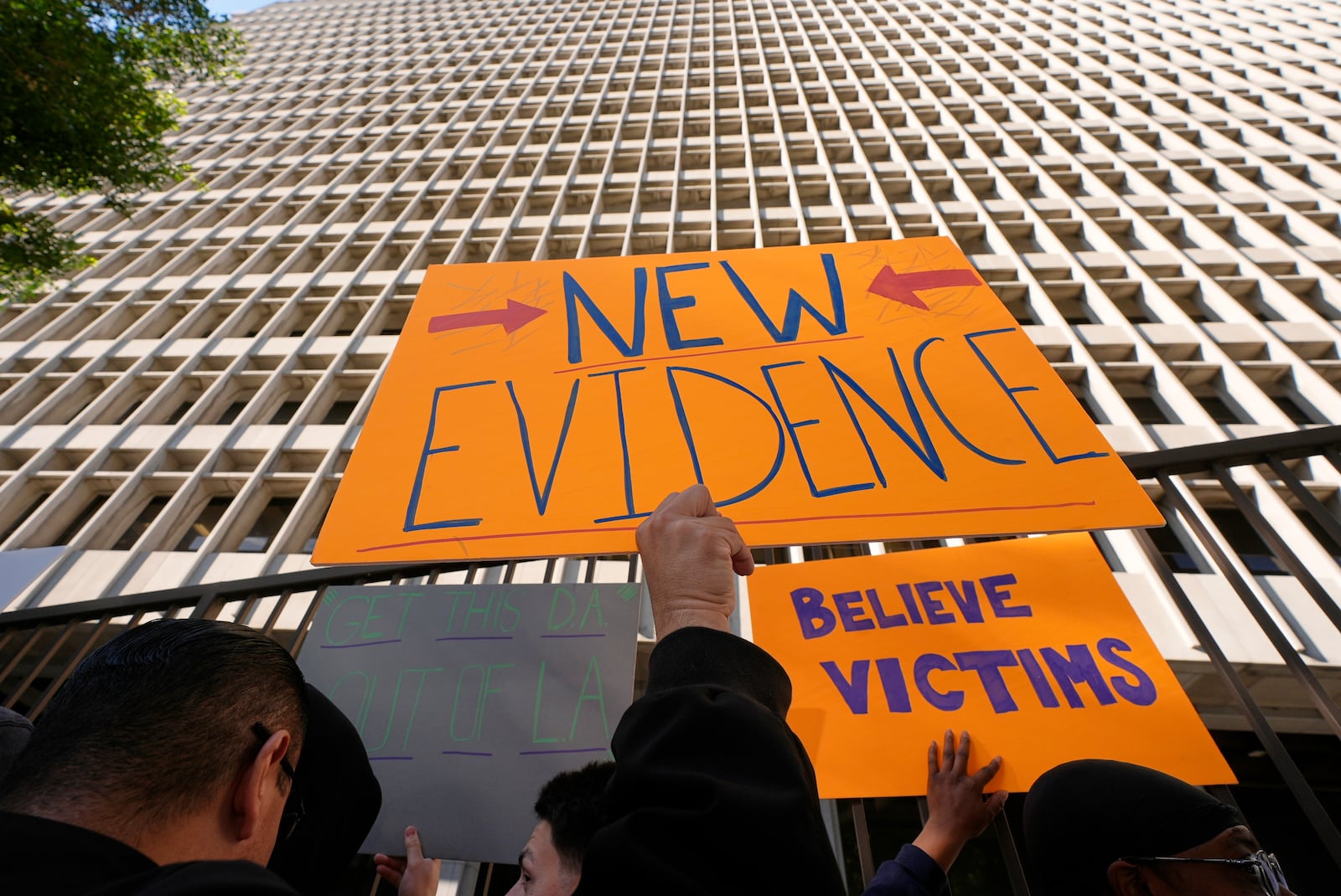 Supporters hold signs during a press conference regarding developments in the Menendez brothers case Thursday, March 20, 2025, in Los Angeles. (AP Photo/Damian Dovarganes)