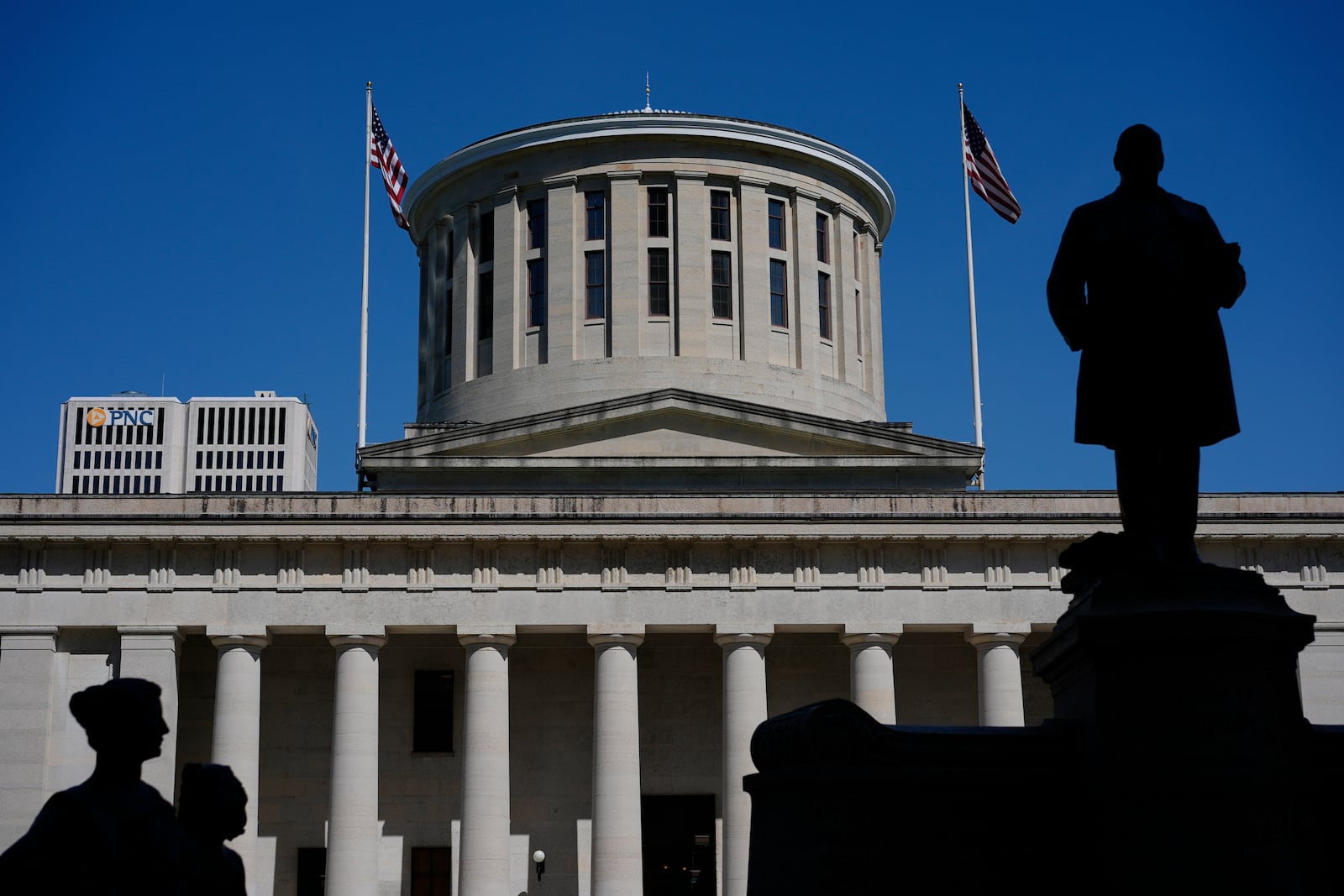 FILE - The William McKinley Monument is silhouetted in front of the west side of the Ohio Statehouse, Monday, April 15, 2024, in Columbus, Ohio. Republican legislative leaders in Ohio say they are negotiating with Democrats to assure President Joe Biden appears on the state's November ballot, but the exact shape of the solution remains murky. (AP Photo/Carolyn Kaster, File)