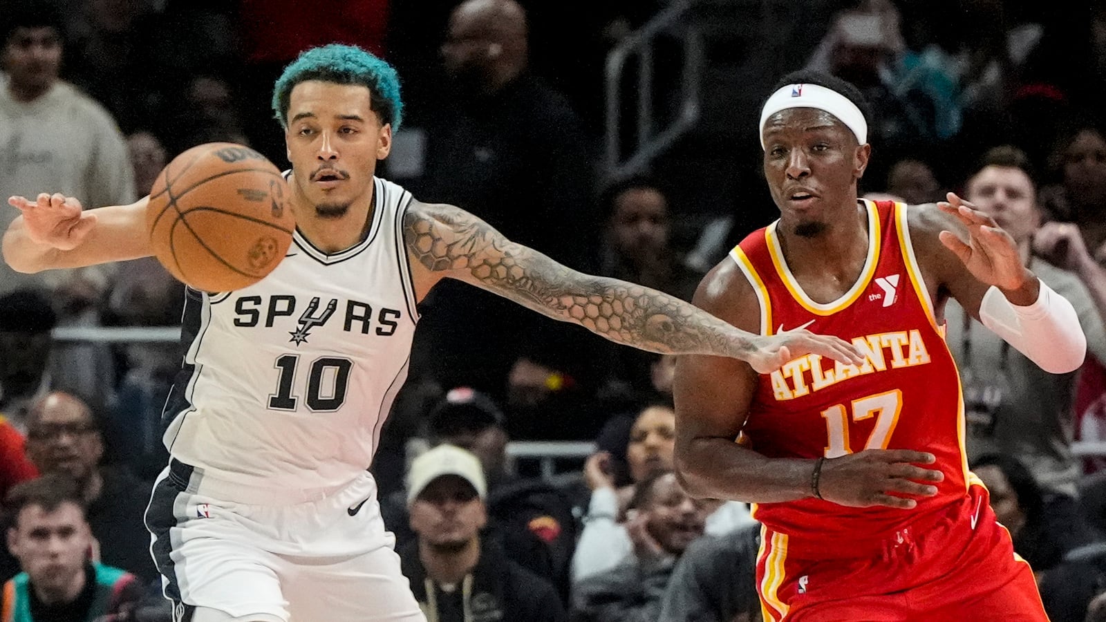 San Antonio Spurs forward Jeremy Sochan (10) and Atlanta Hawks forward Onyeka Okongwu (17) vie for a loose ball during the second half of an NBA basketball game, Wednesday, Feb. 5, 2025, in Atlanta. (AP Photo/Mike Stewart)