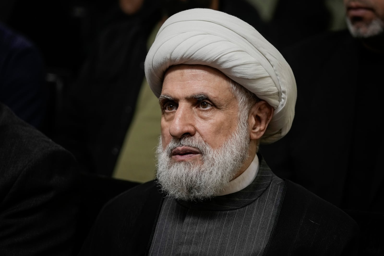 FILE - Hezbollah's deputy leader, Sheikh Naim Kassem, listens to a speech by then-leader Hassan Nasrallah on a screen in southern Beirut, Wednesday, June 19, 2024. (AP Photo/Bilal Hussein, File)