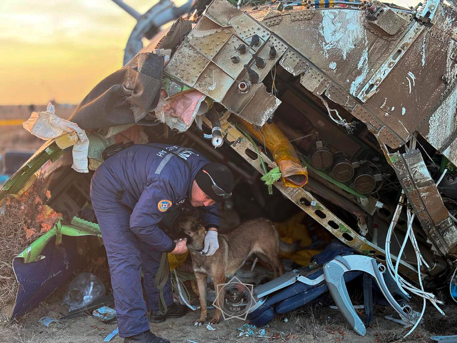 In this photo released by Kazakhstan's Emergency Ministry Press Service, a rescuer search at the wreckage of Azerbaijan Airlines' Embraer 190 laying on the ground near the airport of Aktau, Kazakhstan, Thursday, Dec. 26, 2024. (Kazakhstan's Emergency Ministry Press Service via AP)