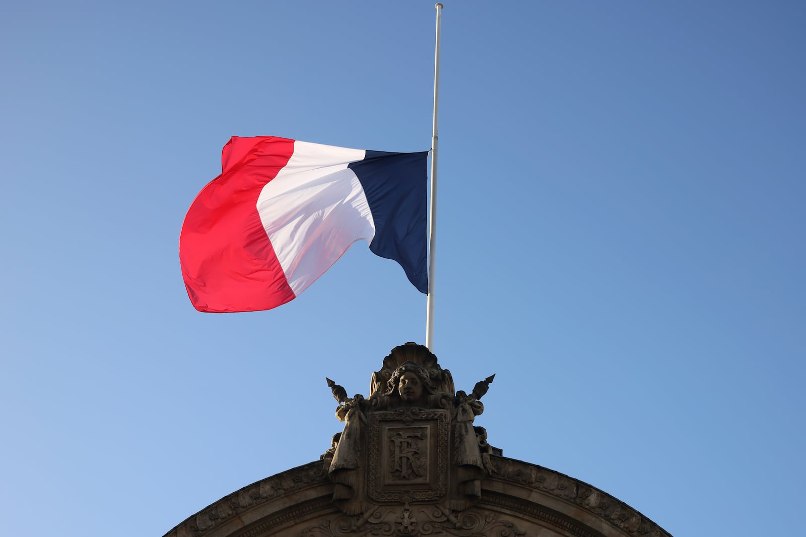 The French flag flies halfmast Monday, Dec. 23, 2024 at the Elysee Palace in Paris after French President Emmanuel Macron declared a day of national mourning for the lives lost when Cyclone Chido ripped through the Indian Ocean territory of Mayotte. (AP Photo/Thomas Padilla)