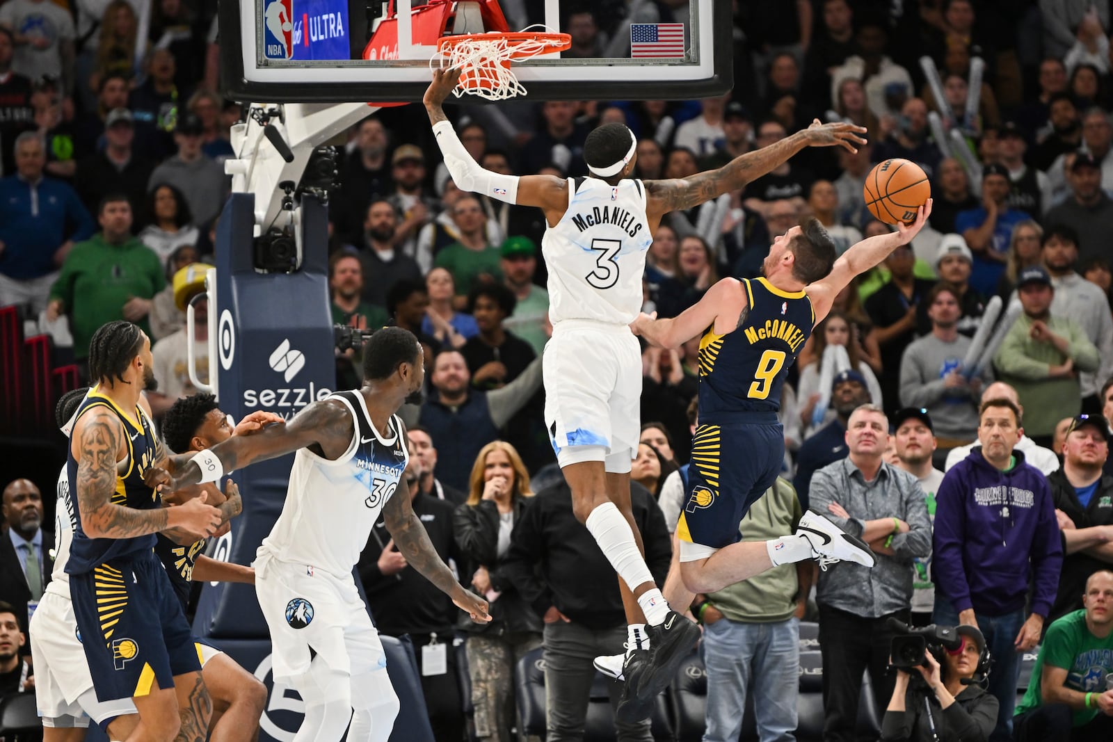 Indiana Pacers guard T.J. McConnell (9) goes up to score against Minnesota Timberwolves forward Jaden McDaniels (3) during overtime of an NBA basketball game Monday, March 17, 2025, in Minneapolis. (AP Photo/Craig Lassig)