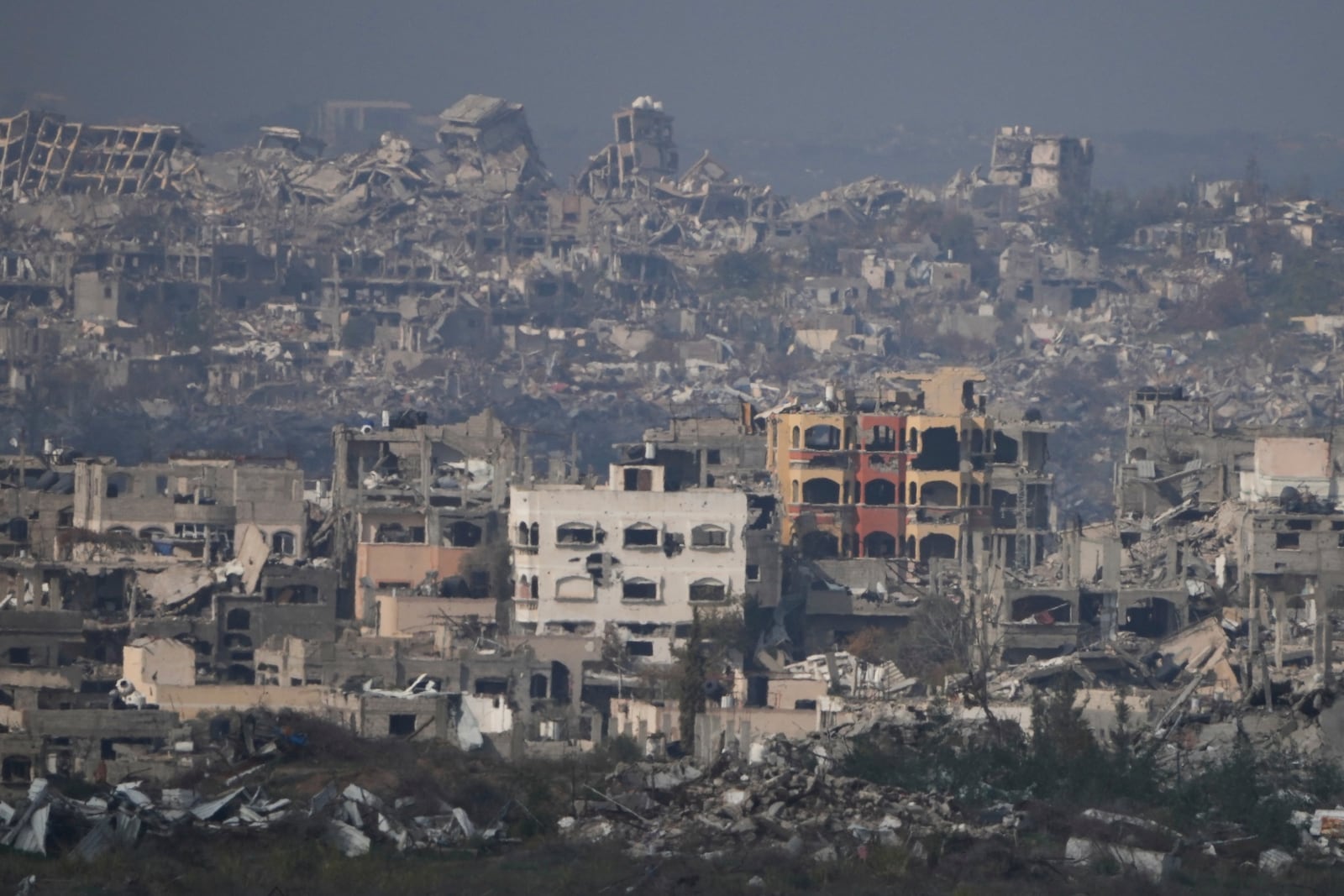 Destroyed buildings by Israeli bombardments as seen inside the Gaza Strip from southern Israel, Thursday, Jan. 16, 2025. (AP Photo/Ariel Schalit)