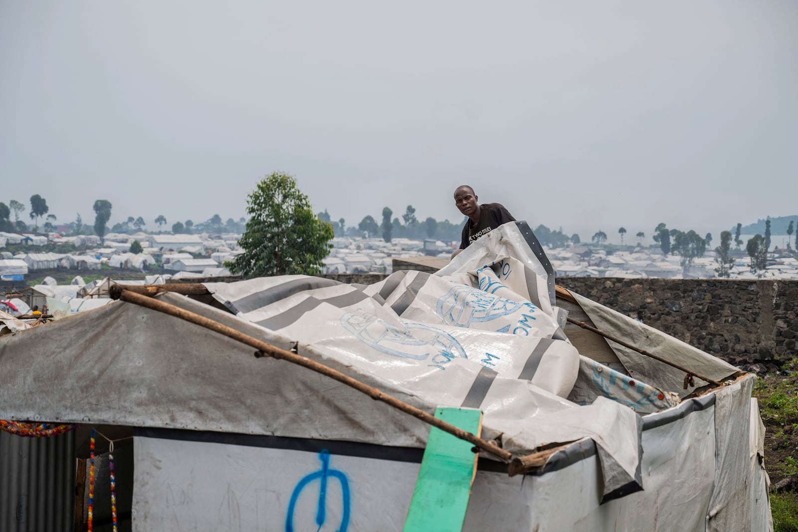 A man displaced by the fighting between M23 rebels and government soldiers prepares to leave the camp following an instruction by M23 rebels in Goma, Democratic Republic of the Congo, Tuesday, Feb. 11, 2025. (AP Photo/Moses Sawasawa)