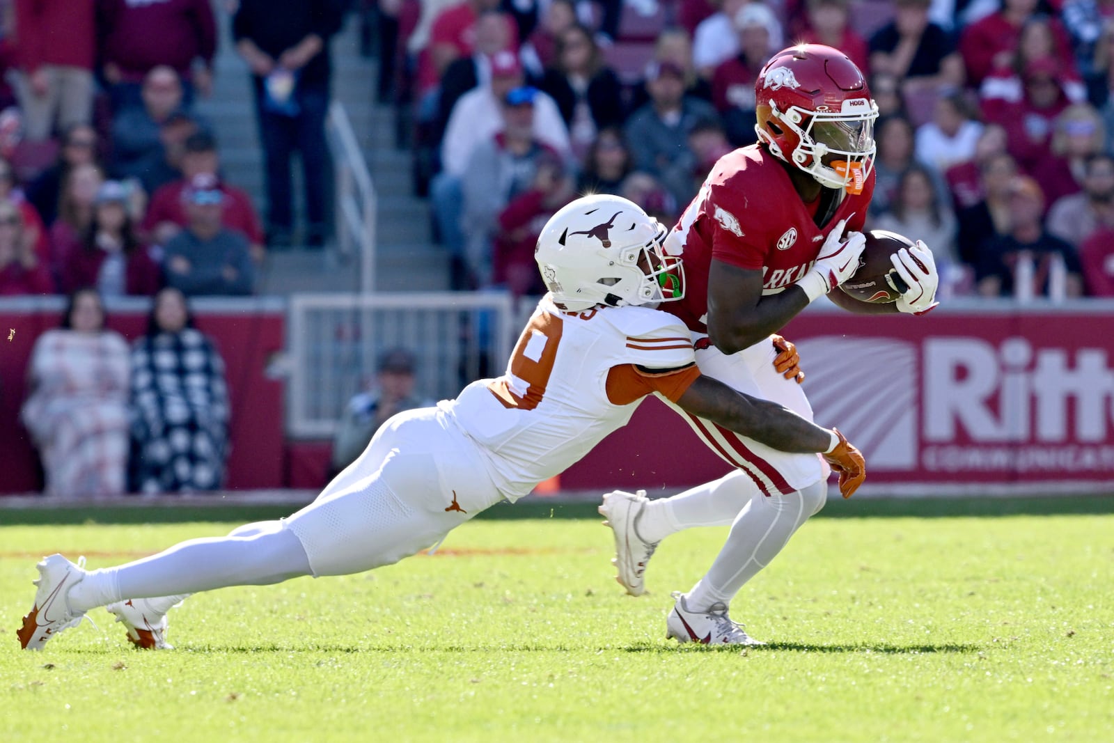 Arkansas running back Rodney Hill (20) is tackled by Texas defensive back Gavin Holmes (9) during the first half of an NCAA college football game Saturday, Nov. 16, 2024, in Fayetteville, Ark. (AP Photo/Michael Woods)