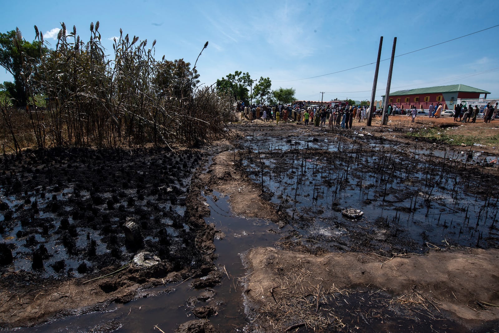 People gather at the scene of a fuel tanker explosion in Majiya town, Nigeria, Wednesday, Oct. 16, 2024. (AP Photo/Sani Maikatanga)