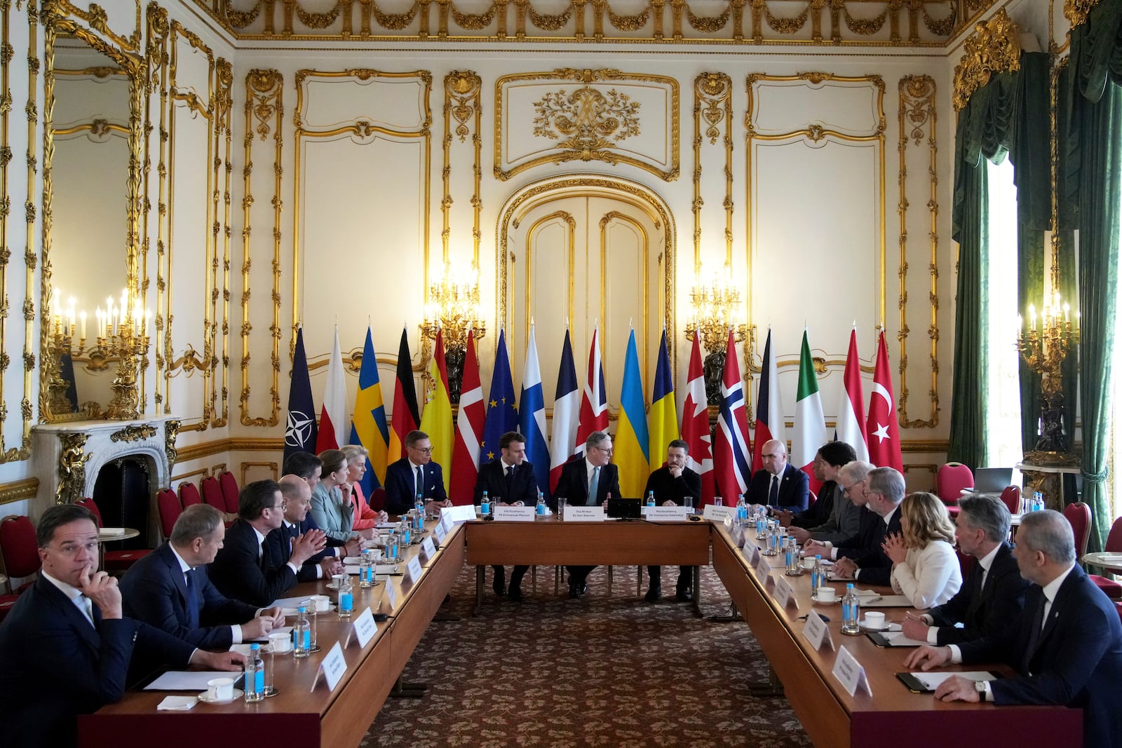 Britain's Prime Minister Keir Starmer, center, French President Emmanuel Macron, center left, and Ukraine's President Volodymyr Zelenskyy, center right, attend a meeting with European leaders during a summit on Ukraine at Lancaster House in London, Sunday, March 2, 2025. (AP Photo/Christophe Ena, Pool)