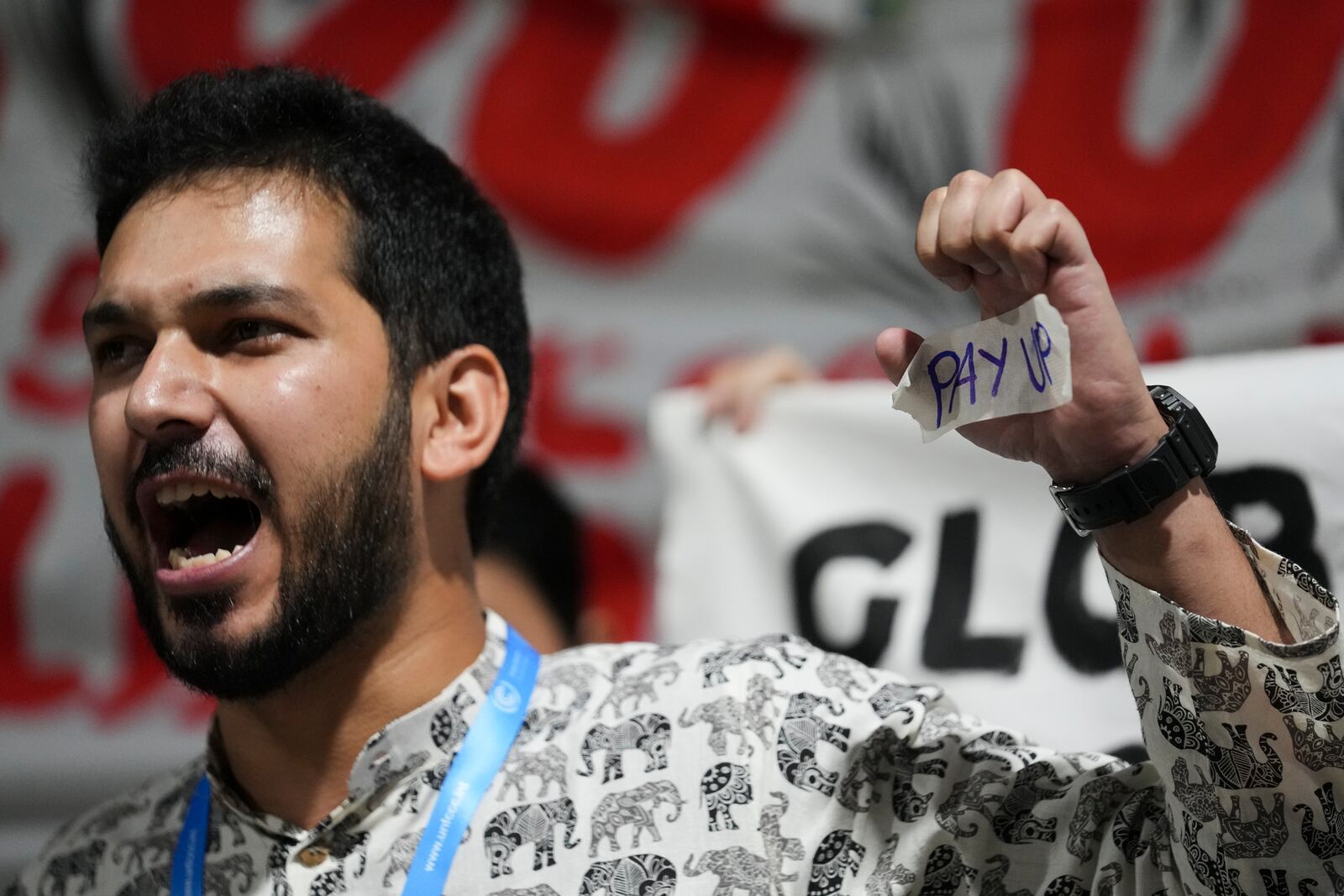 An activist displays "pay up" on his hand during a demonstration for climate finance at the COP29 U.N. Climate Summit, Friday, Nov. 22, 2024, in Baku, Azerbaijan. (AP Photo/Sergei Grits)