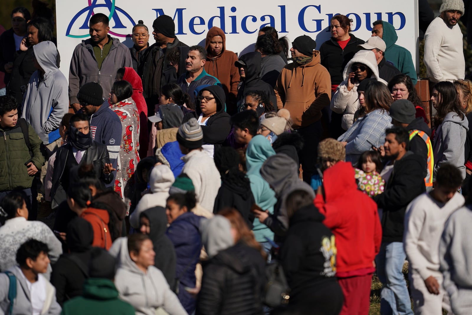 People wait as school buses arrive at a unification site following a shooting at the Antioch High School in Nashville, Tenn., Wednesday, Jan. 22, 2025. (AP Photo/George Walker IV)