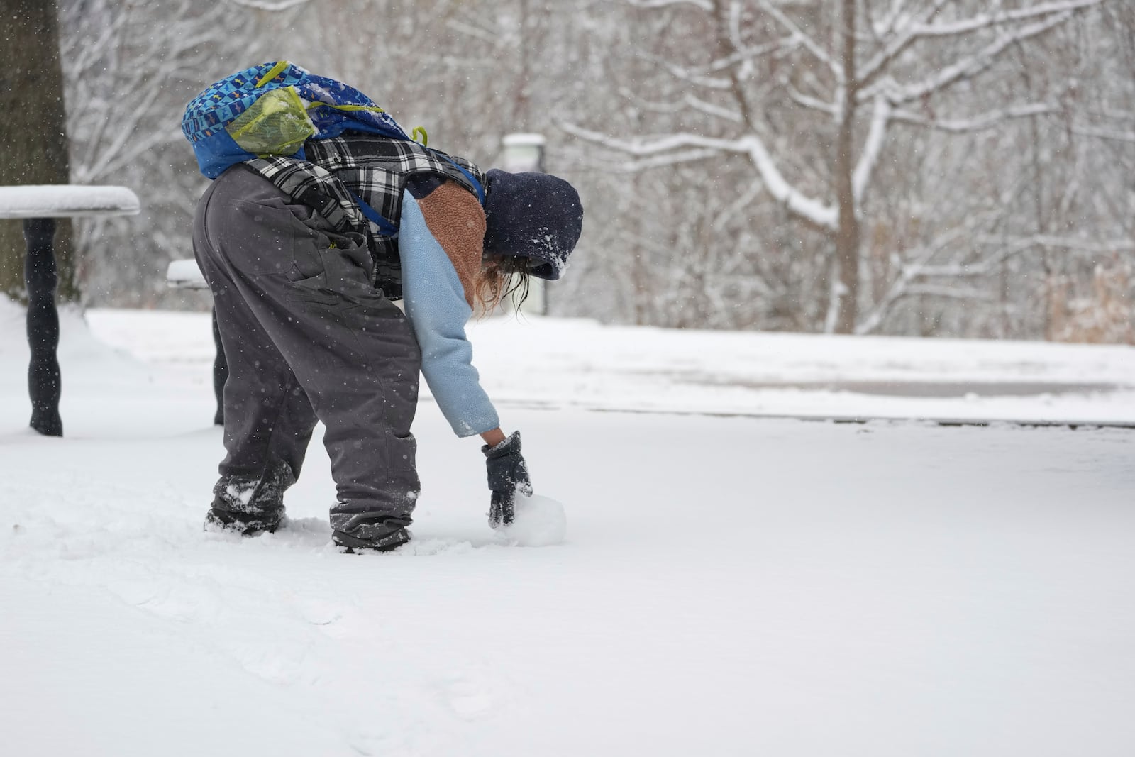 Tiffany Prichard rolls a snow ball to build a snowman Friday, Jan 10, 2025, in Nashville, Tenn. (AP Photo/George Walker IV)