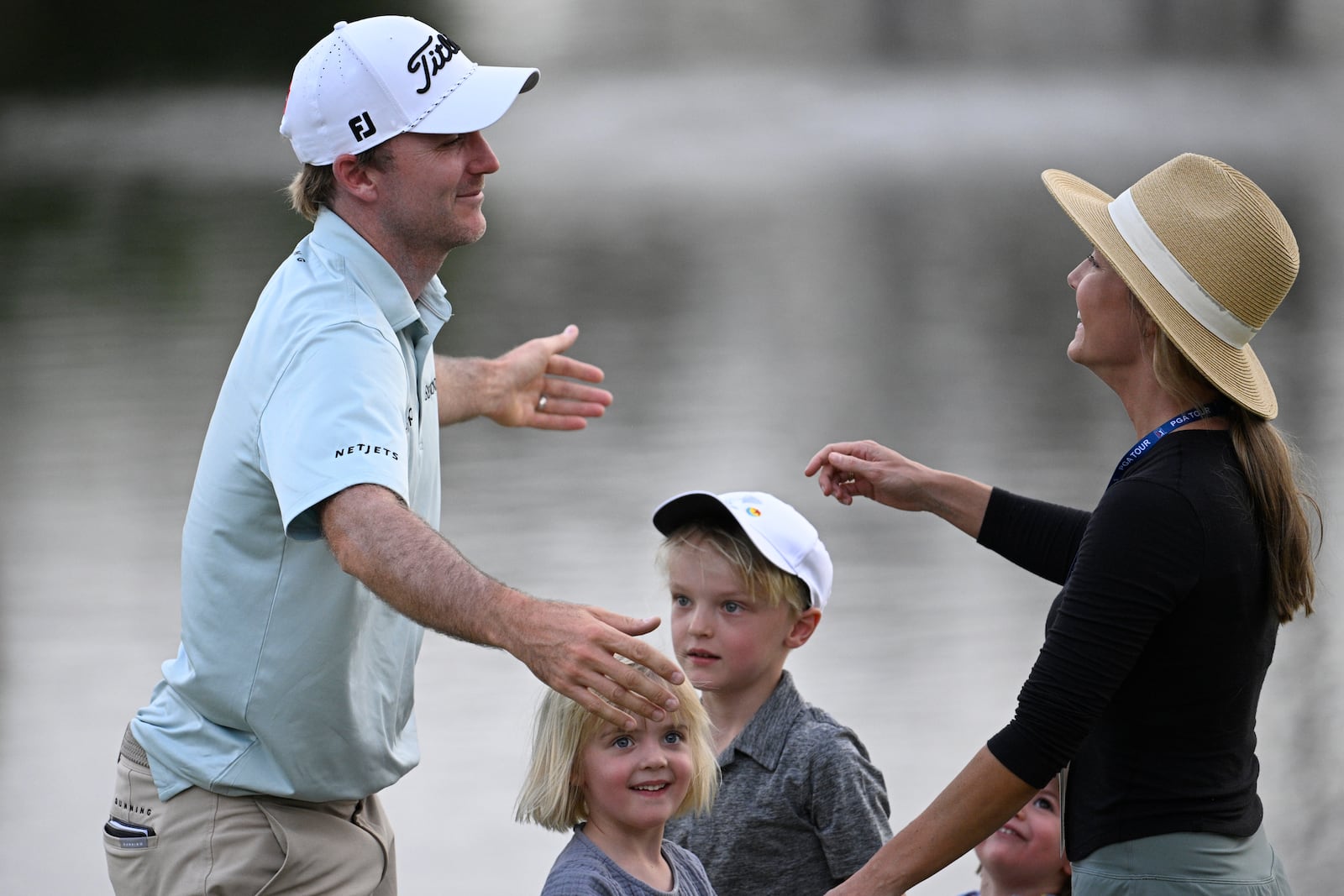 Russell Henley, left, is met by his children, Ruth, second from left, Robert, center, and Jane, and wife Teil on the 18th green after winning the Arnold Palmer Invitational at Bay Hill golf tournament, Sunday, March 9, 2025, in Orlando, Fla. (AP Photo/Phelan M. Ebenhack)