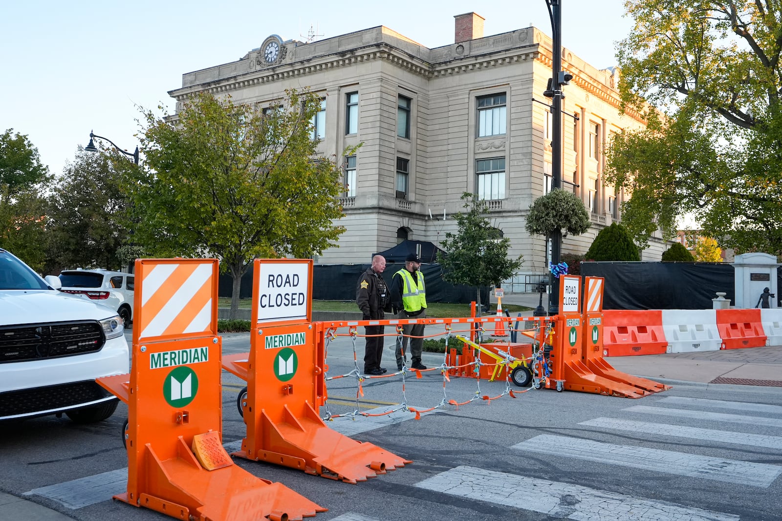 Security stand by a gate outside the Carroll County Courthouse where the trial of Richard Allen, accused of the slayings of two teenage girls in 2017, is set to begin in Delphi, Ind., Friday, Oct. 18, 2024. (AP Photo/Michael Conroy)