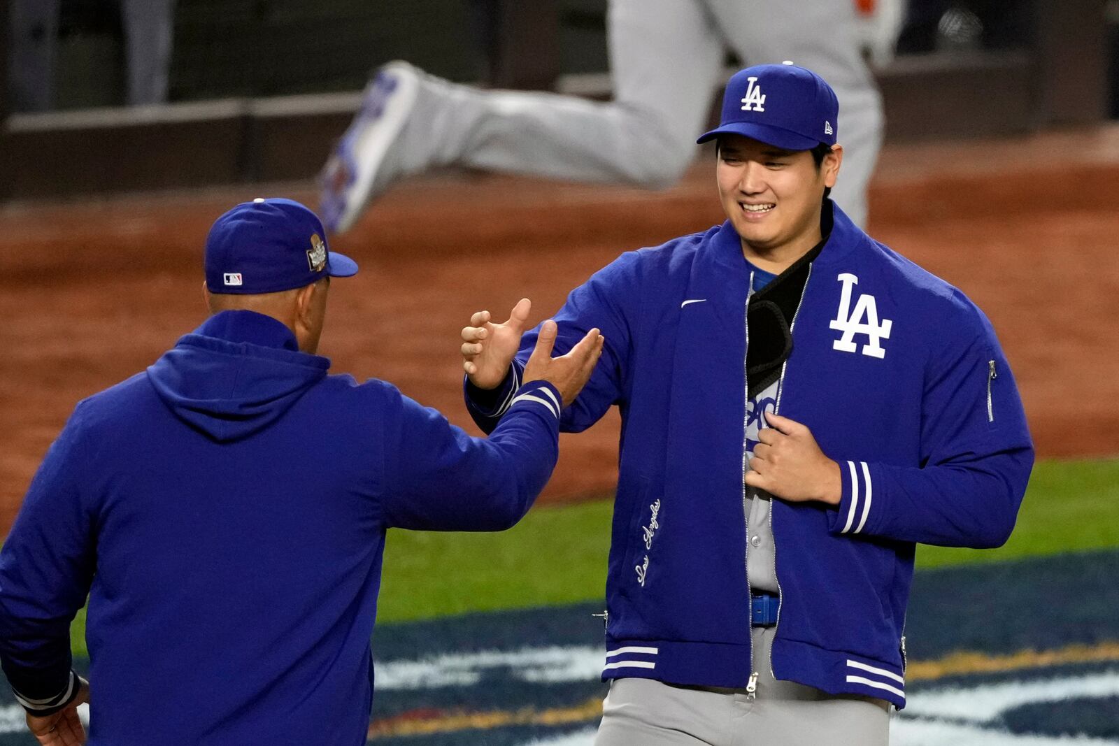 Los Angeles Dodgers' Shohei Ohtani, right, is greeted by manager Dave Roberts during team introductions before Game 3 of the baseball World Series against the New York Yankees, Monday, Oct. 28, 2024, in New York. (AP Photo/Seth Wenig)