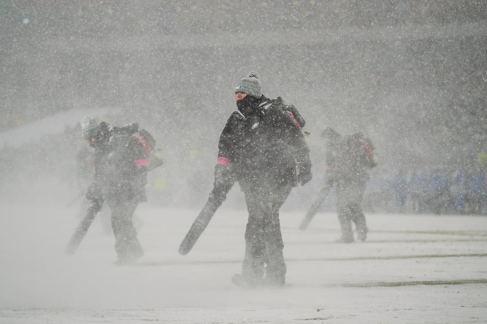 Snow is cleared during the second half of an NFL football NFC divisional playoff game between the Philadelphia Eagles and the Los Angeles Rams on Sunday, Jan. 19, 2025, in Philadelphia. (AP Photo/Matt Slocum)