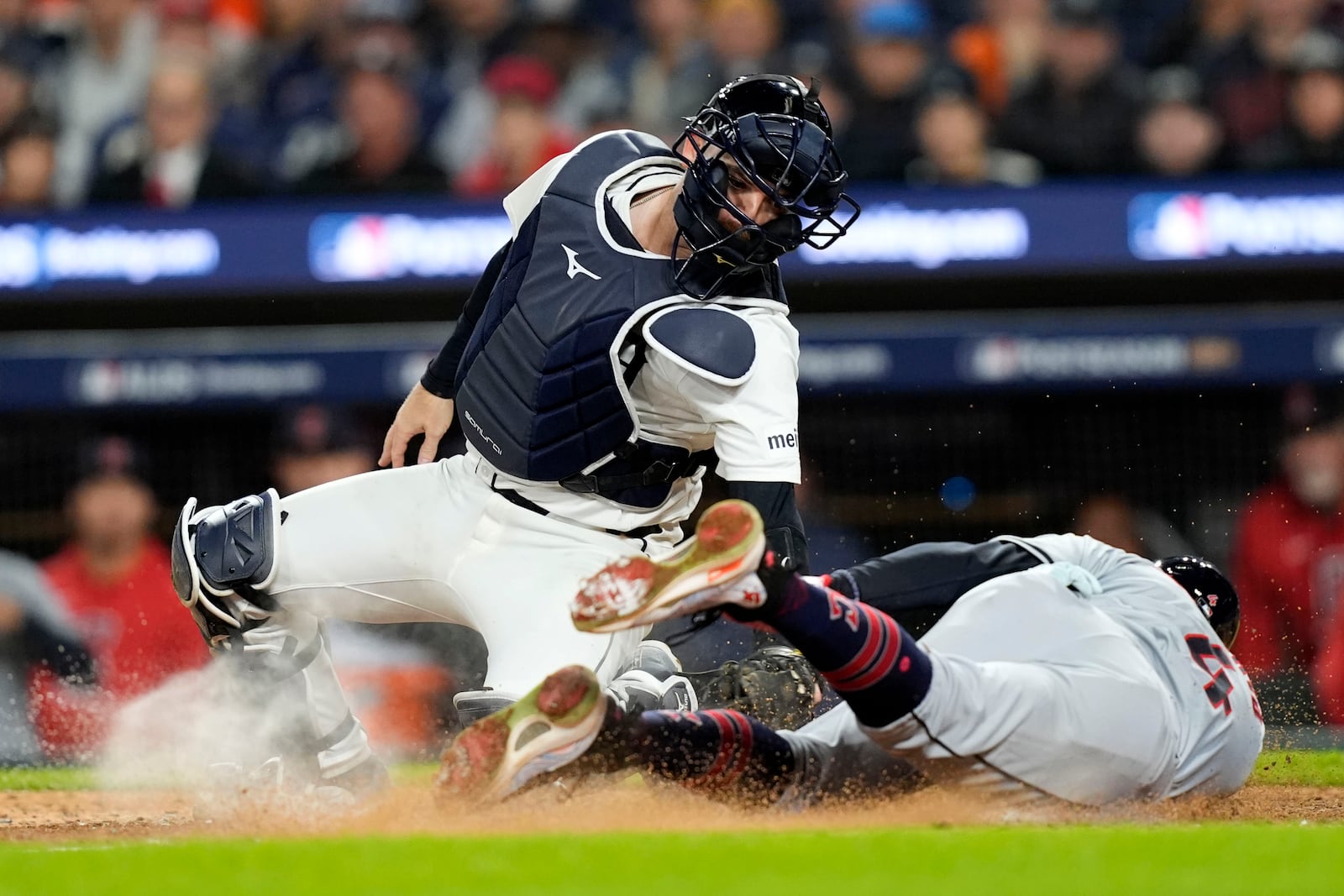 Cleveland Guardians' Brayan Rocchio, right, scores in front of Detroit Tigers catcher Jake Rogers, left, on a bunt by David Fry in the eighth inning of Game 4 of a baseball American League Division Series, Thursday, Oct. 10, 2024, in Detroit. (AP Photo/Carlos Osorio)