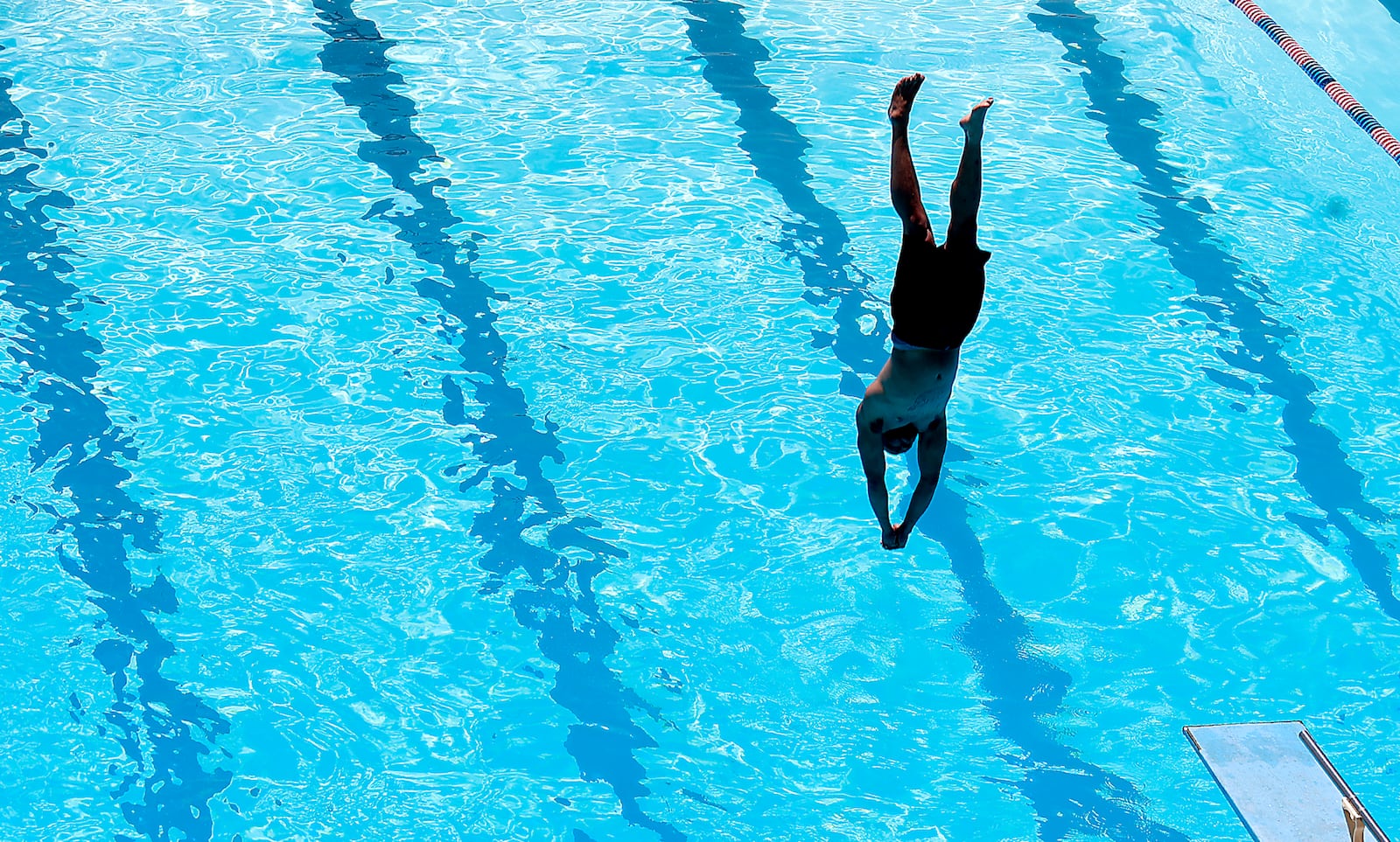 A diver hangs over the water just before breaking the surface Friday, June 2, 2023 at Splash Zone Aquatic Center in Springfield. BILL LACKEY/STAFF