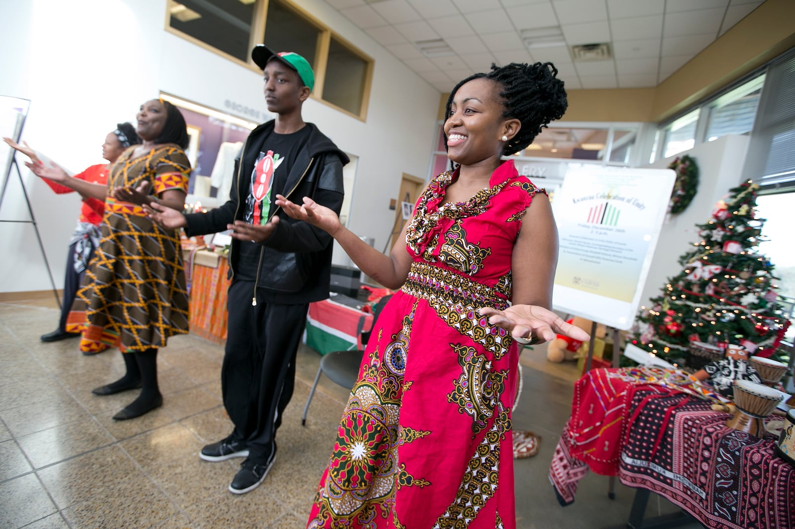 Carol Kariuki, far right, joins, from left, Theresa Garcia, Elizabeth Kahura and Andrew Kahura, 14, as they encourage the audience dance along with them during a Kwanzaa Celebration at the George Washington Carver Museum on Friday, December 26, 2014. The event was celebrating the first day of Kwanzaa which focuses on Unity (Umoja). DEBORAH CANNON / AMERICAN-STATESMAN