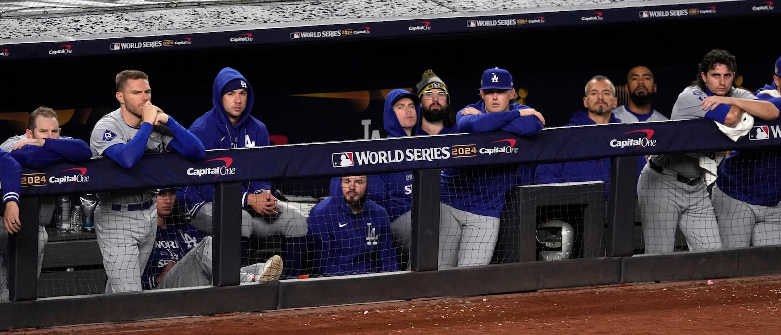 Los Angeles Dodgers players watch from the dugout during the ninth inning in Game 4 of the baseball World Series against the New York Yankees, Tuesday, Oct. 29, 2024, in New York. (AP Photo/Seth Wenig)