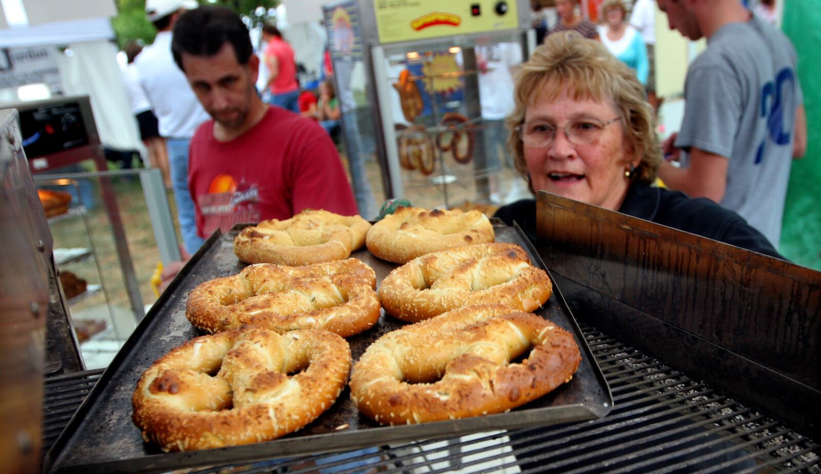 Keeping a family tradition, Donna Bishop (right) pulls fresh pretzels from an oven at the Germantown Pretzel Festival Saturday, Sept. 27. Bishop's father, Lester Peck, was a founder of the festival. Staff photo by Jan Underwood