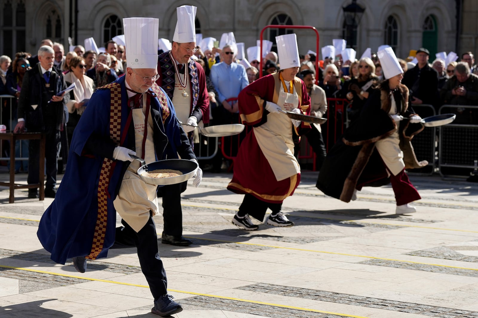 Runners compete during a traditional pancake race by livery companies at the Guildhall in London, Tuesday, March 4, 2025.(AP Photo/Frank Augstein)