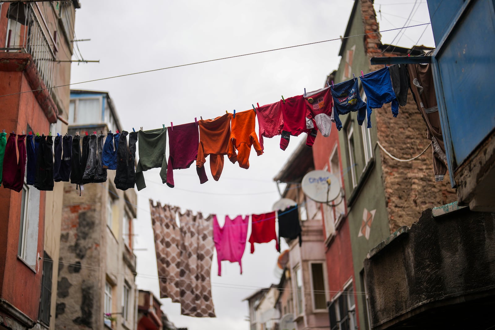 Children's laundry hangs over a street in the Tarlabasi neighborhood in Istanbul, Turkey, Wednesday, Dec. 4, 2024. (AP Photo/Francisco Seco)