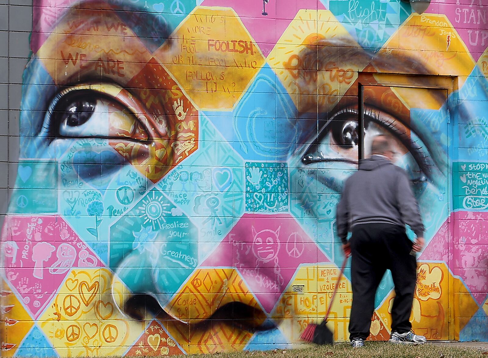 A Springfield YMCA employee walks past the Project Jericho mural on the north side of the YMCA. BILL LACKEY/STAFF