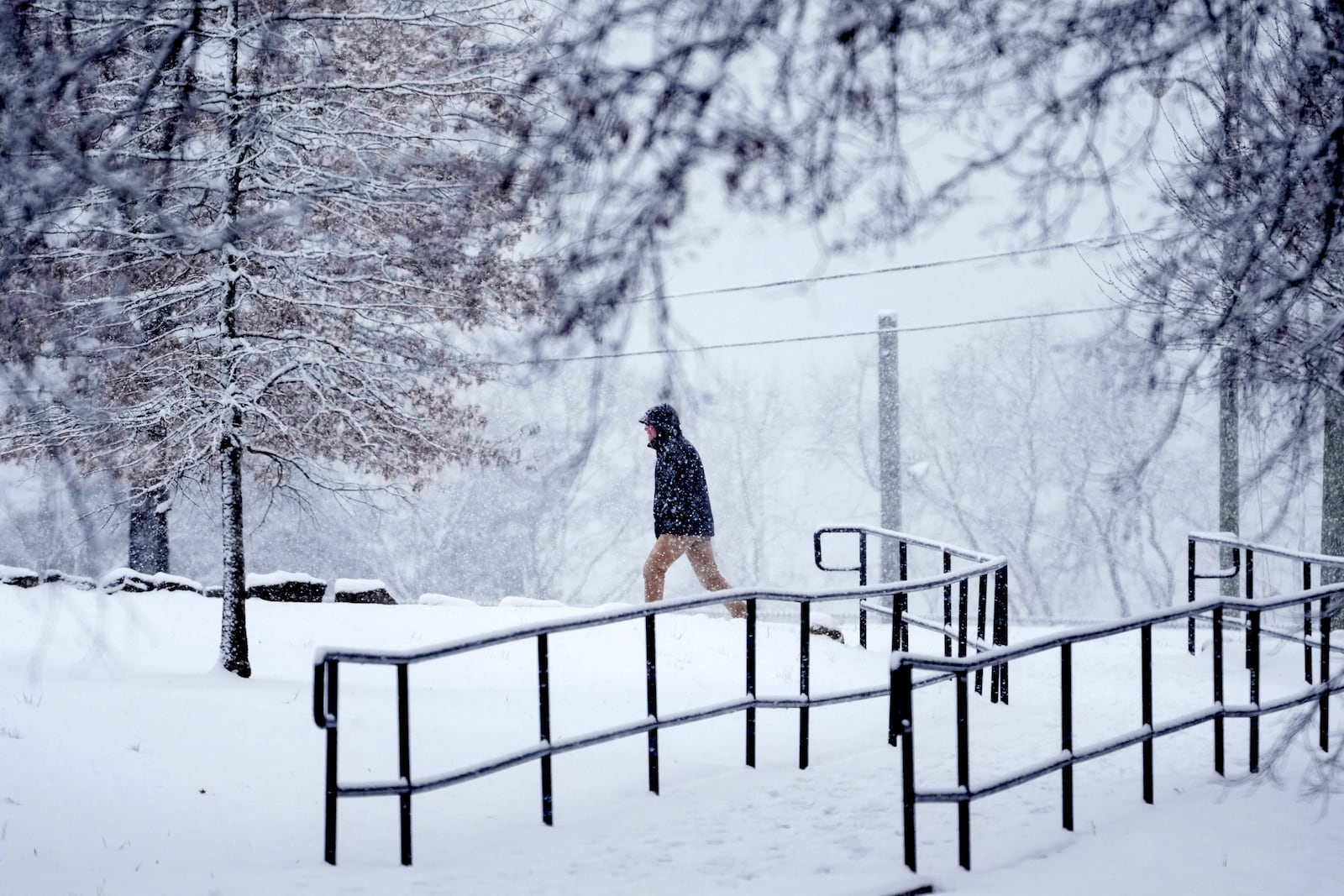 A person walks through the snow Friday, Jan. 10, 2025, in Nashville, Tenn. (AP Photo/George Walker IV)