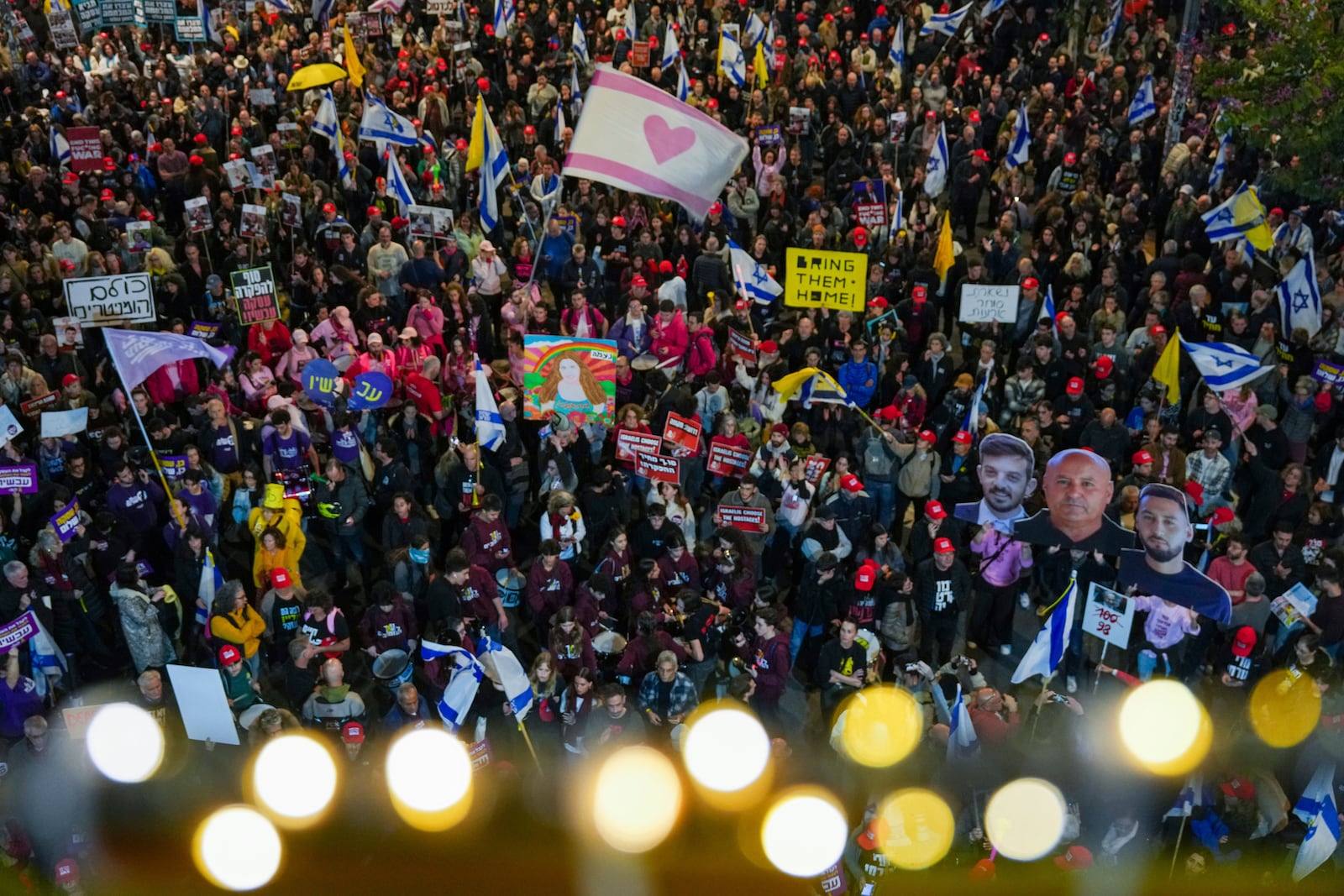 Demonstrators wave Israeli flags and signs during a protest calling for the immediate release of the hostages held in the Gaza Strip by Hamas militant group, in Tel Aviv, Israel, Saturday, Jan. 11, 2025. (AP Photo/Ariel Schalit)