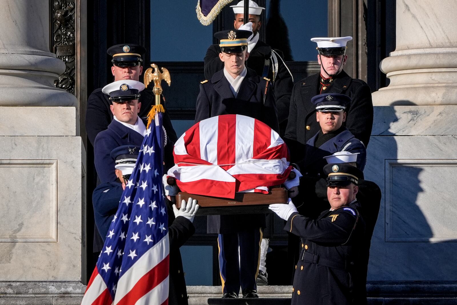 The flag-draped casket of former President Jimmy Carter is carried from the U.S. Capitol on the way to a state funeral at the National Cathedral, in Washington, Thursday, Jan. 9, 2025. (AP Photo/J. Scott Applewhite)