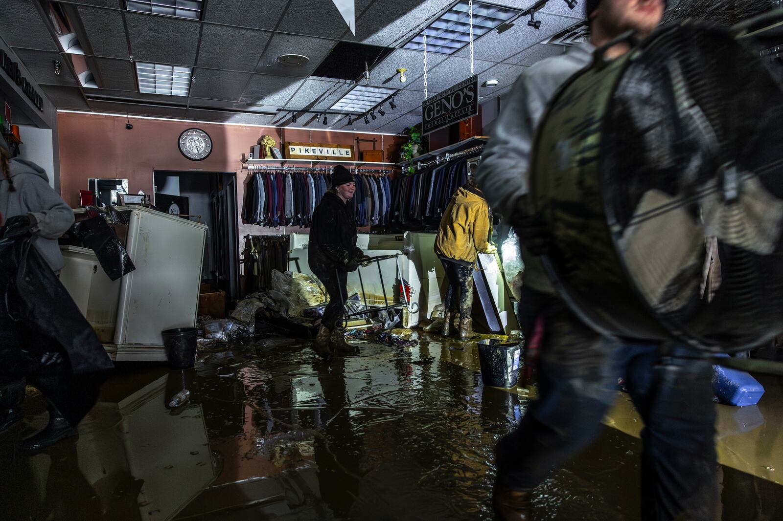 People work to recover clothing from The Men's Corner after flooding in Pike County, Ky., Tuesday, Feb. 18, 2025, following a storm the previous weekend. (Ryan C. Hermens/Lexington Herald-Leader via AP)