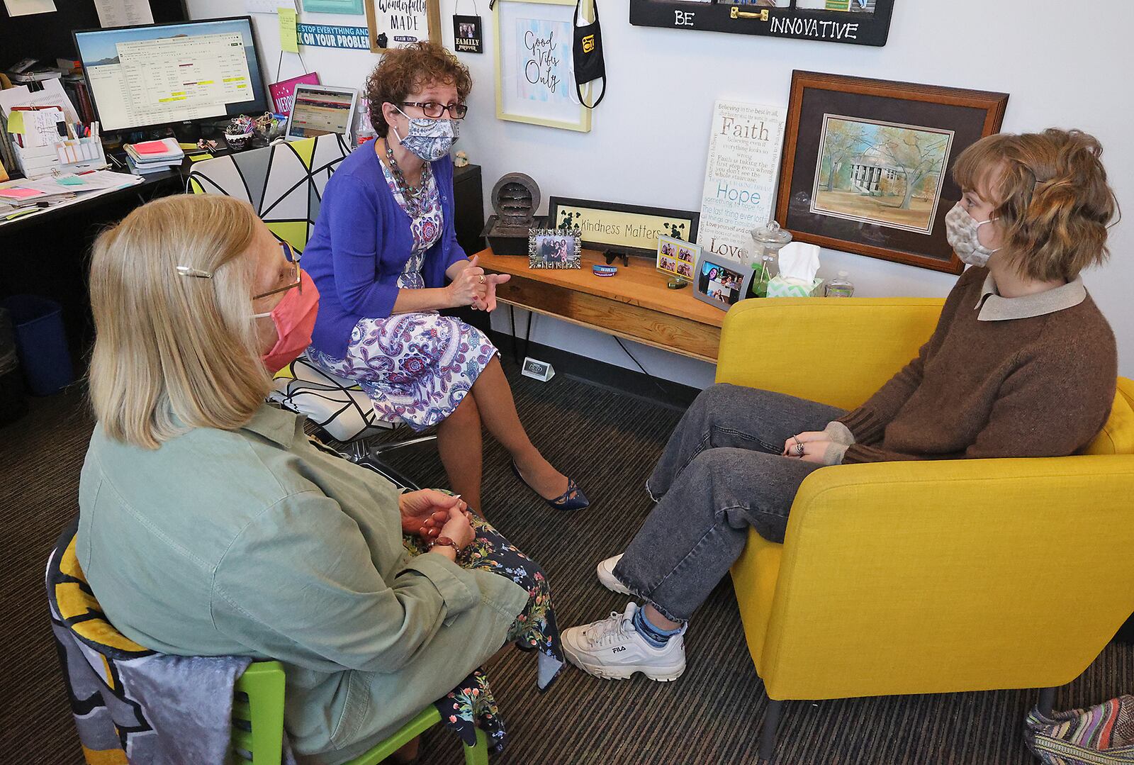 Dr. Jill Pfister, Global Impact STEM Academy College and Career Pathway Coordinator, left, and Pam Clark, the school's guidance councelor, talk with senior Laura Kamper about college next year. BILL LACKEY/STAFF