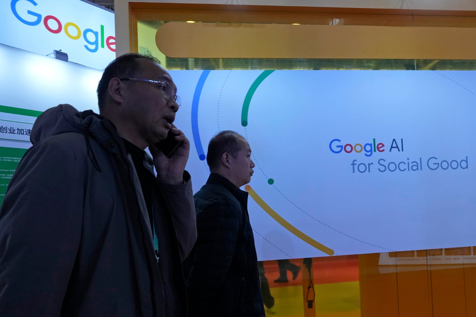 Visitors past by a Google booth promoting Artificial Intelligence at a supply chain expo in Beijing, Wednesday, Nov. 27, 2024. (AP Photo/Ng Han Guan)