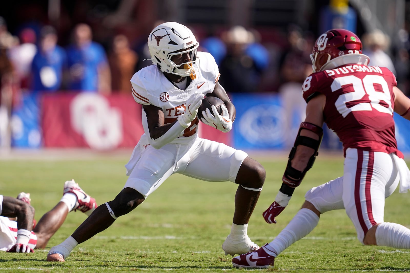 Texas running back Quintrevion Wisner (26) carries the ball as Oklahoma linebacker Danny Stutsman (28) moves in to make the stop in the first half of an NCAA college football game in Dallas, Saturday, Oct. 12, 2024. (AP Photo/Tony Gutierrez)